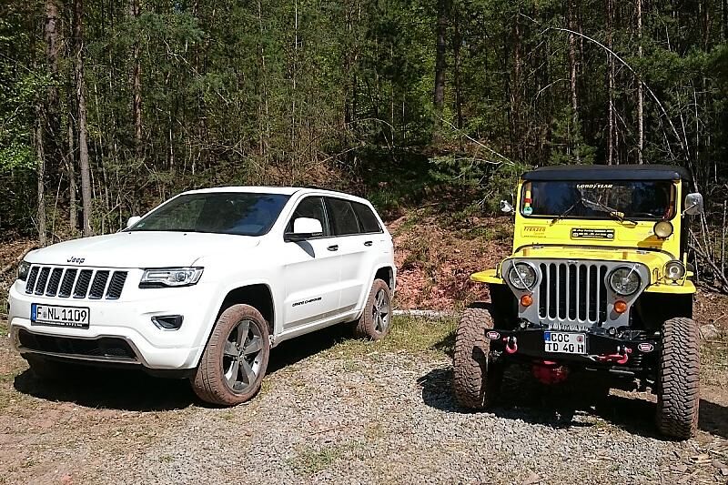 Der Jeep Grand Cherokee neben seinem 1951 gebauten Urahn, dem Willys Jeep.