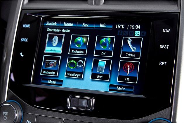 Das Navi-Display ist in eine moderne Klavierlack-Oberfläche eingepasst, doch darunter schaut ein Schiebegriff aus uraltem Hartplastik hervor - damit lässt man übrigens das Display nach oben schwenken und öffnet das Geheimfach dahinter
