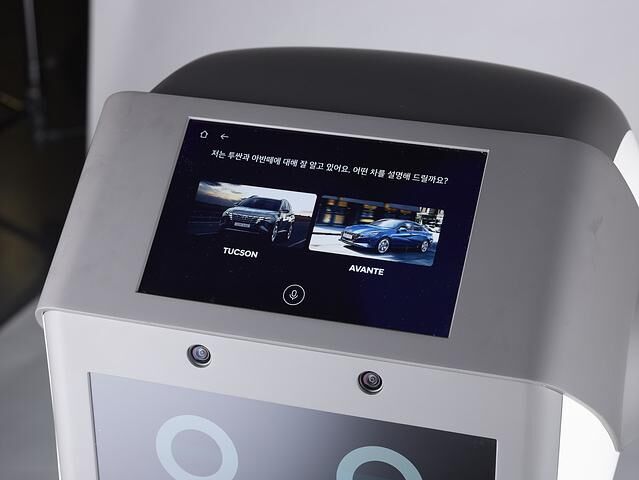 Der humanoide Verkaufsberater liefert Erklärungen zum Fahrzeug und Technologien, indem er sich drahtlos mit einem großen Bildschirm am jeweiligen Standort im Showroom verbindet