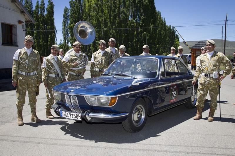 Eine Militärkapelle bewundert einen BMW 2000 CS
