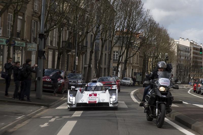 Tom Kristensen lenkt seinen Audi R18 e-tron quattro nach der Präsentation durch die Straßen von Le Mans