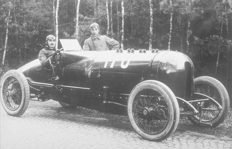 Carl Jörns am Steuer eines 260 PS 12,3 Liter Opel-Rennwagens von 1914. Neben ihm steht sein Beifahrer Kurt C. Volkhart.