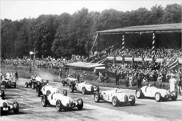 Grand Prix-Szene 1937: Rosemeyer (Nr. 5) in vorgerückter Sitzposition vor dem Motor
