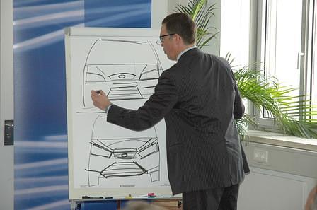 Ford-Designer Chris Bird demonstriert mit ein paar schnellen Strichen am Zeichenbrett die Änderungen am C-Max