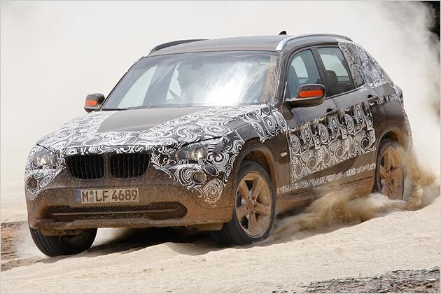 Der noch leicht getarnte BMW X1 23d xDrive auf lockerem Sand