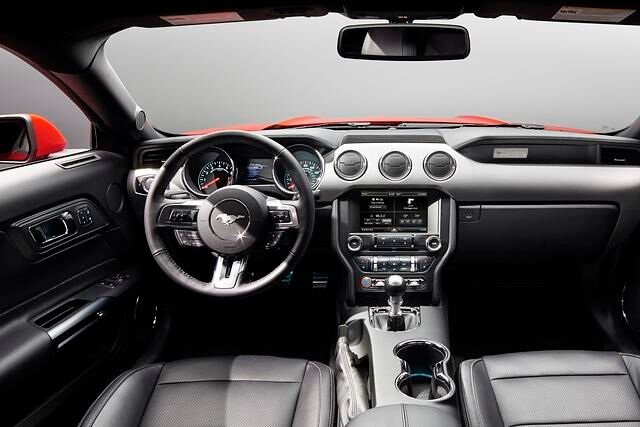 Das Cockpit wird beherrscht vom kultig-knackigen Lenkrad, auf dem natürlich statt der Ford-Pflaume das Pony galoppiert.