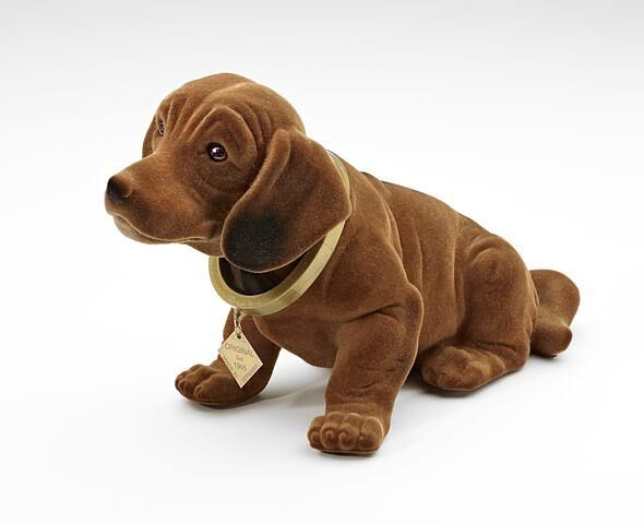 965 fertigt der Unternehmer Rakso Oskar Schneider eine kleine Hundefigur mit beweglichem Kopf und meldet sie wenig später in Italien zum Patent an