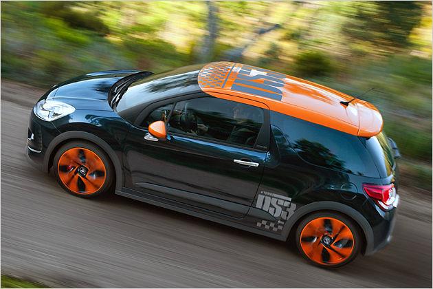 Dach, Felgen und Außenspiegelkappen des schwarzen Fahrzeugs leuchten in knalligem Orange