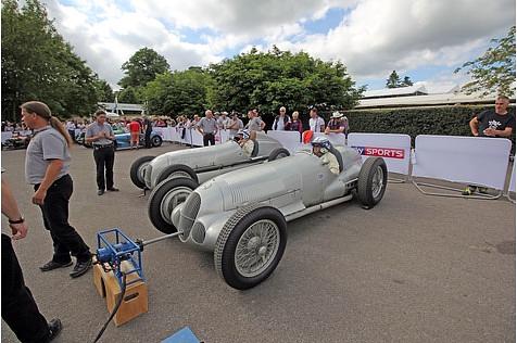 Rennfahrer Roland Asch und Jochen Mass in ihren lauten Mercedes W25 und W125.