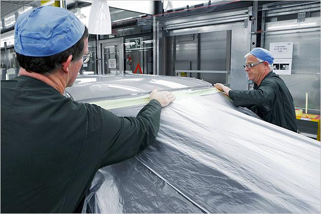 Von Hand wird das Plastik am Dach abgeklebt