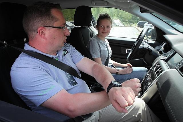 Instruktor Sascha Herweg erklärt Nora beim Land Rover Kinderfahrtraining, wie man richtig lenkt