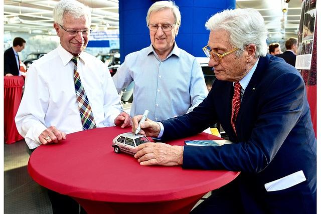 Giorgetto Giugiaro (rechts) signiert den Volkswagen Golf GTI Generation 1