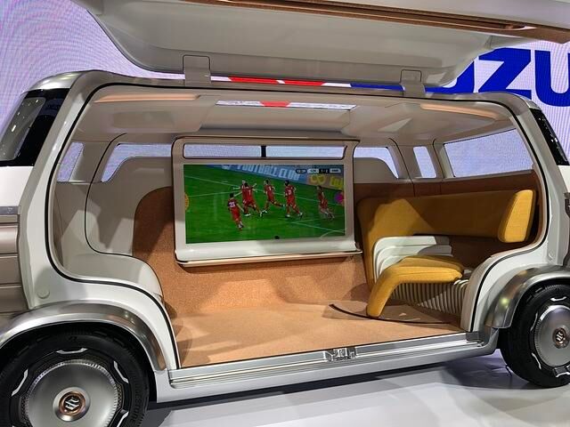 Wer fit und gesund ist, reist  mit dem Suzuki Hanare, einem Van-artigen Kastenwagen, der innen an der Längsseite einen riesigen Fernseher hat