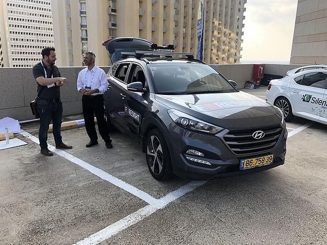 Benyamin Parto (rechts) mit seinem Hyundai SUV, auf dessen Dach vier Kameras montiert sind - zwei optische und zwei Wärmebildkameras