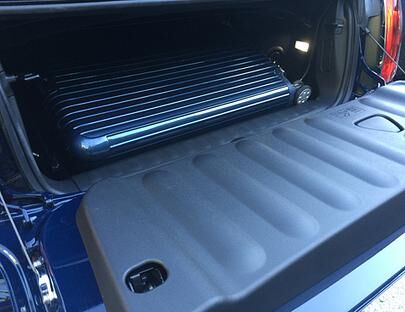 Der Kofferraum ist und bleibt klein. Aber dank einer speziellen Mechanik lässt sich bei geschlossenem Verdeck zumindest das Beladen erleichtern.