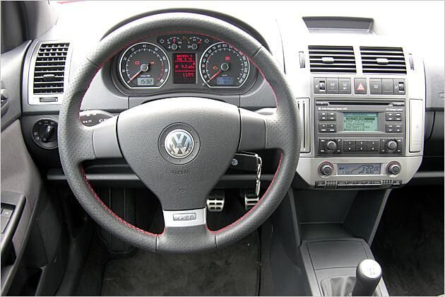 Lederlenkrad mit roten Nähten und silbernem GTI-Logo sowie Pedale in Alu-Optik