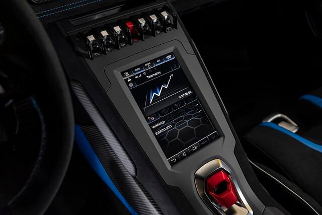 Die Wahlknöpfe für Vorwärts, Rückwärts oder „Neutral“ sind unter einer knallroten Klappe versteckt. Hochkant darüber ein Bildschirm fürs Navi oder diverse vor allem rennspezifische Anzeigen