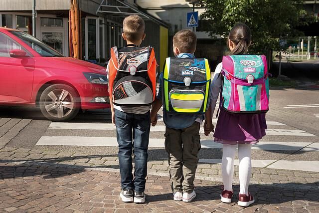 Querungshilfen wie Zebrastreifen bieten auf dem Schulweg Sicherheit, die Schulranzen sollten mit Reflektoren für mehr Sichtbarkeit ausgestattet sein
