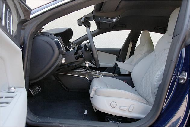 Fahrer und Beifahrer nehmen auf Sportsitzen mit integrierten Kopfstützen Platz